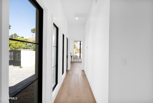 hall with light wood finished floors and baseboards