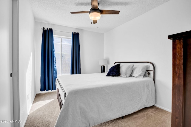 carpeted bedroom with ceiling fan, baseboards, and a textured ceiling