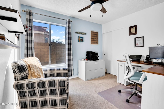 office featuring a textured ceiling, a ceiling fan, and light colored carpet