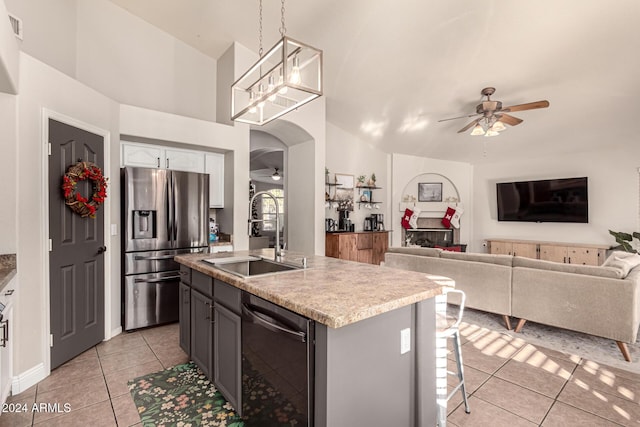 kitchen featuring sink, stainless steel appliances, pendant lighting, gray cabinets, and a kitchen island with sink