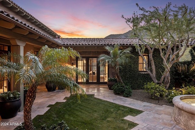 exterior space with french doors and a yard