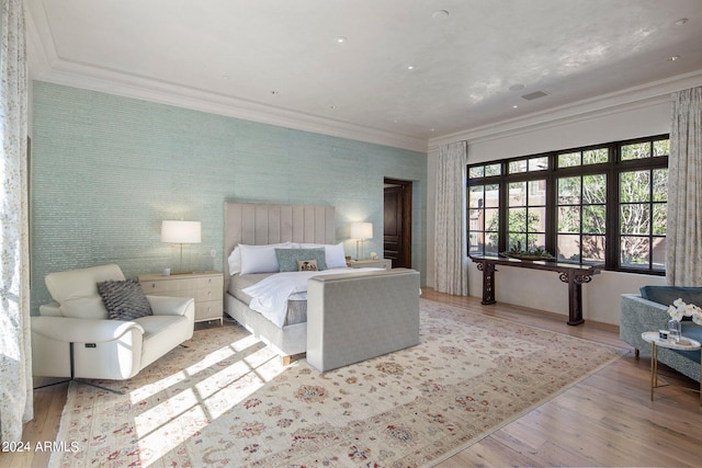 bedroom with ornamental molding and hardwood / wood-style flooring