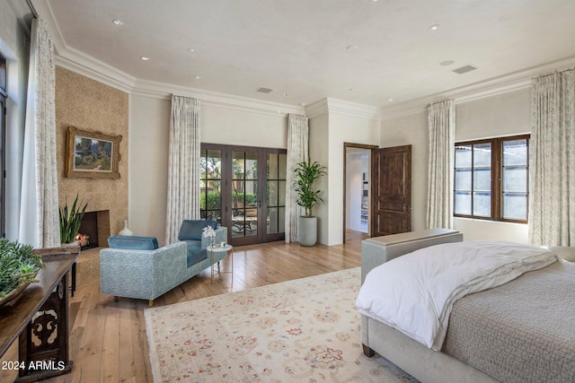 bedroom with hardwood / wood-style floors, crown molding, french doors, and access to outside