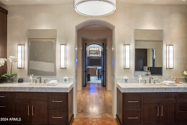 bathroom featuring wood-type flooring and dual vanity