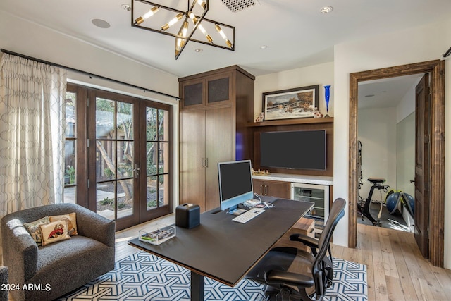 office area featuring light hardwood / wood-style flooring, french doors, and an inviting chandelier