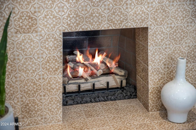 details with a tiled fireplace and tile floors