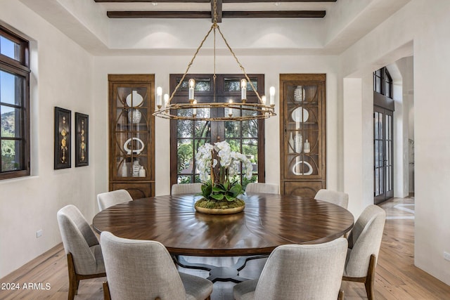 dining area featuring light hardwood / wood-style flooring, a tray ceiling, and an inviting chandelier