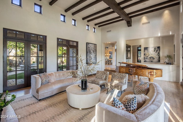 living room with wood-type flooring, french doors, a healthy amount of sunlight, and beam ceiling