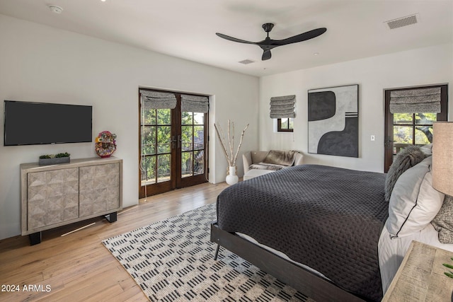 bedroom featuring french doors, multiple windows, access to exterior, and light hardwood / wood-style flooring