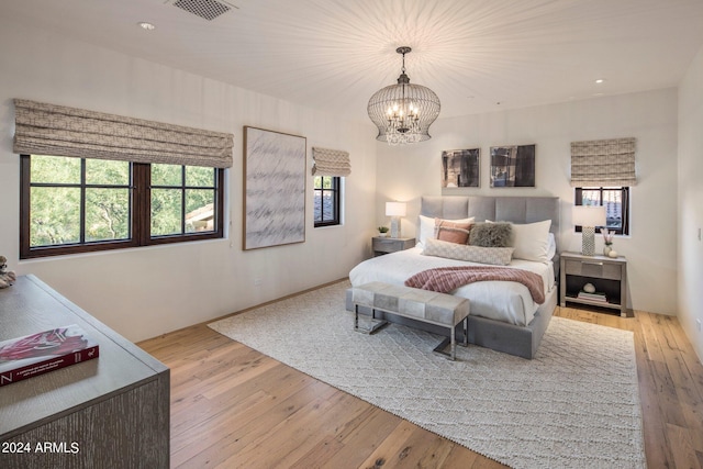 bedroom featuring a notable chandelier and light hardwood / wood-style flooring