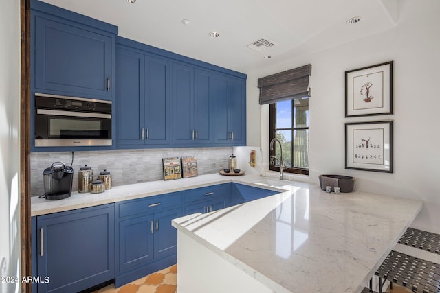 kitchen with oven, sink, and blue cabinetry