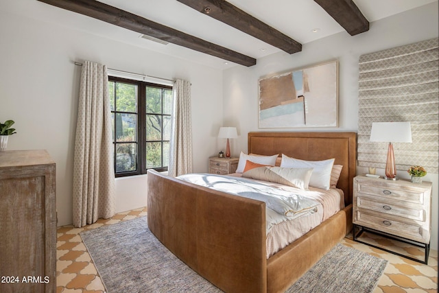 bedroom featuring beamed ceiling and light tile floors