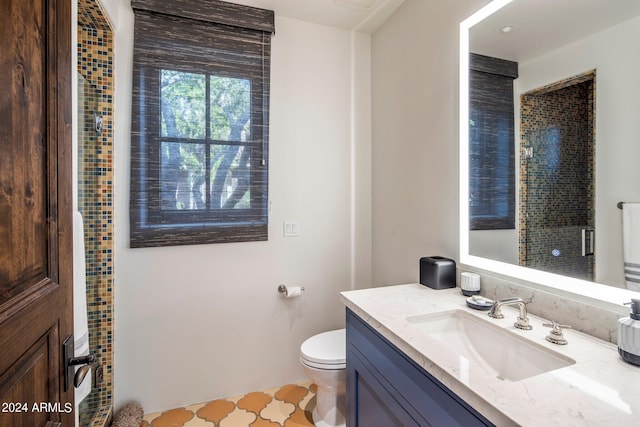 bathroom with vanity with extensive cabinet space, toilet, and tile floors