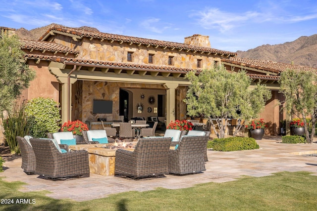 rear view of house with a patio, a mountain view, and an outdoor hangout area