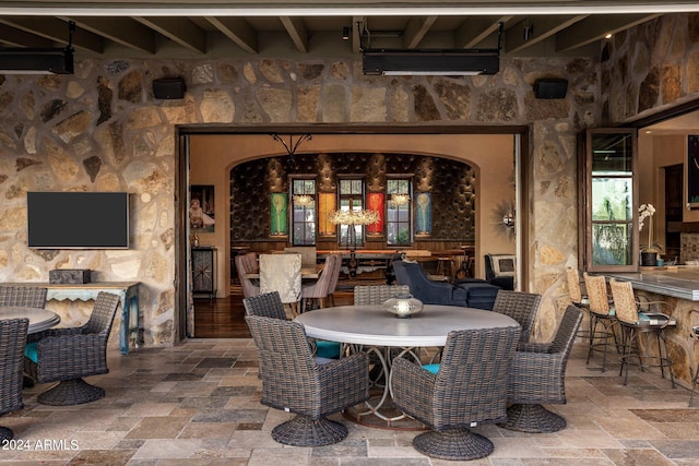 dining area featuring wood-type flooring and beamed ceiling