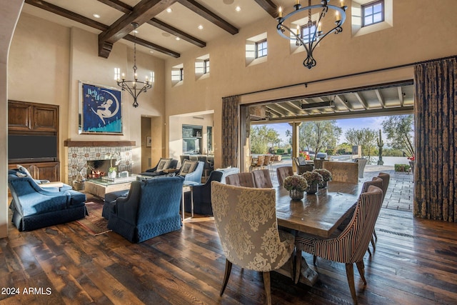 dining room featuring beamed ceiling, a fireplace, dark wood-type flooring, a towering ceiling, and a notable chandelier