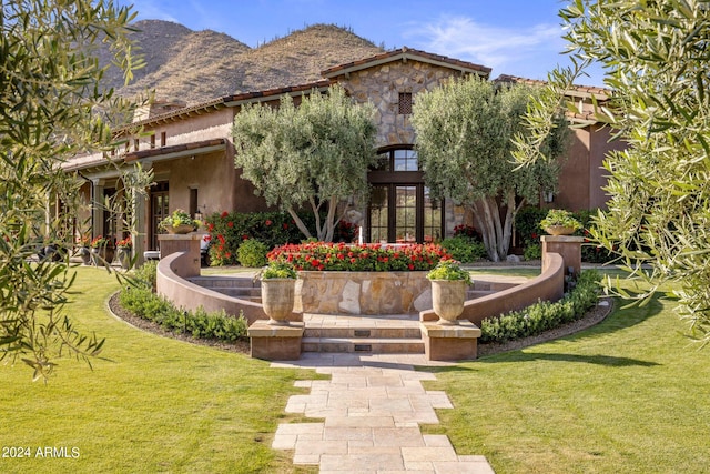 view of front of house with a mountain view and a front yard