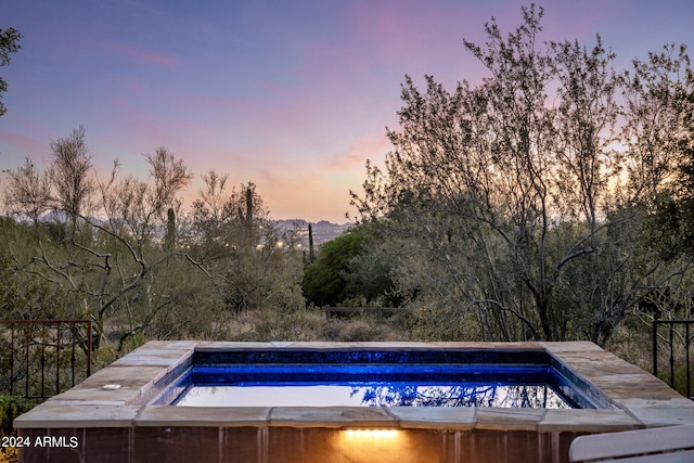 view of pool at dusk