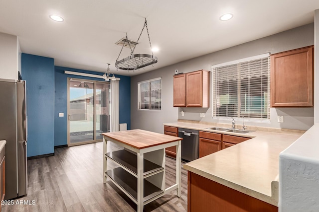 18008 W Tina Ln, Surprise, AZ 85387 - kitchen with stainless steel appliances, a sink, recessed lighting, light wood-style floors, and brown cabinets