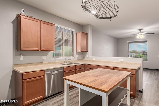 18008 W Tina Ln, Surprise, AZ 85387 - kitchen featuring stainless steel dishwasher, a sink, a peninsula, butcher block countertops, and light wood-style flooring