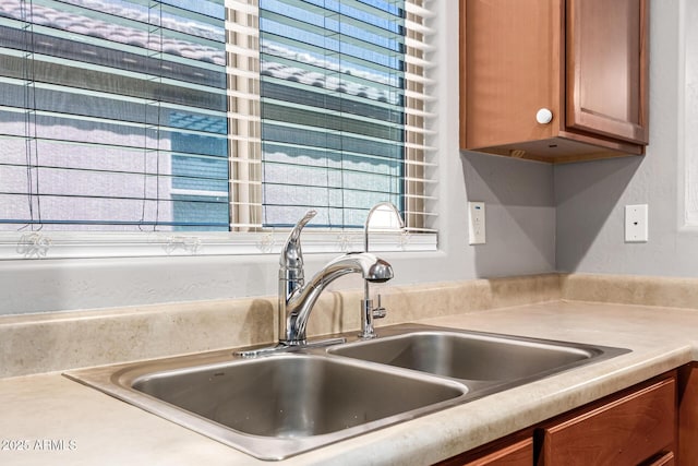 18008 W Tina Ln, Surprise, AZ 85387 - kitchen view of a sink, light countertops, and brown cabinetry