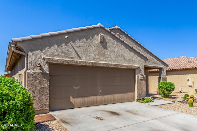 18008 W Tina Ln, Surprise, AZ 85387 - view of front of home featuring stucco siding, a garage, driveway, and a tile roof