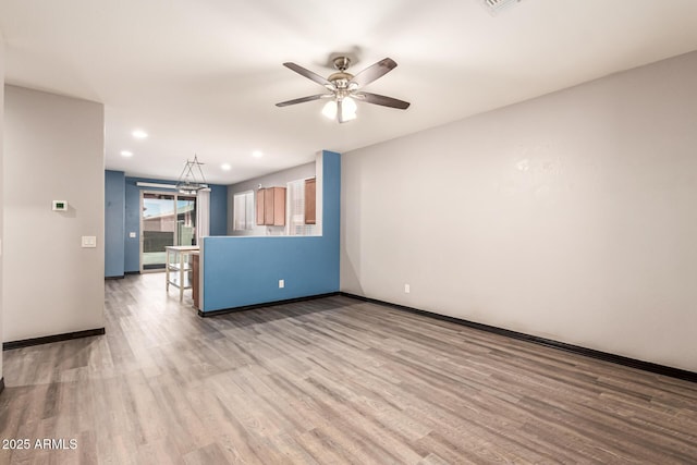 18008 W Tina Ln, Surprise, AZ 85387 - unfurnished living room with wood finished floors, a ceiling fan, baseboards, and recessed lighting