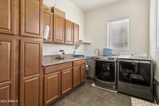 clothes washing area featuring dark tile patterned flooring, cabinets, independent washer and dryer, and sink