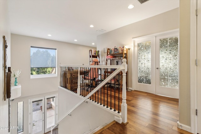 stairs featuring hardwood / wood-style floors and french doors