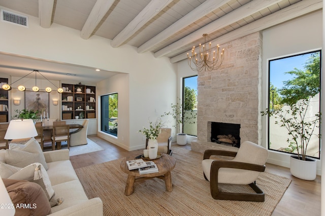 3186 E Stella Ln, Phoenix, AZ 85016 - living area featuring a chandelier, wood finished floors, beamed ceiling, a fireplace, and baseboards