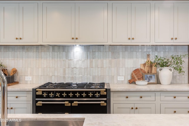 3186 E Stella Ln, Phoenix, AZ 85016 - kitchen featuring range with two ovens, backsplash, and white cabinets