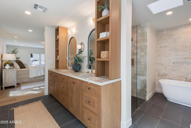 3186 E Stella Ln, Phoenix, AZ 85016 - ensuite bathroom with a soaking tub, double vanity, recessed lighting, tile patterned floors, and a skylight