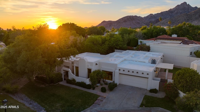 3186 E Stella Ln, Phoenix, AZ 85016 - view of front facade featuring a garage, driveway, stucco siding, and a mountain view