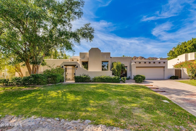 3186 E Stella Ln, Phoenix, AZ 85016 - pueblo revival-style home with a gate, driveway, stucco siding, and an attached garage