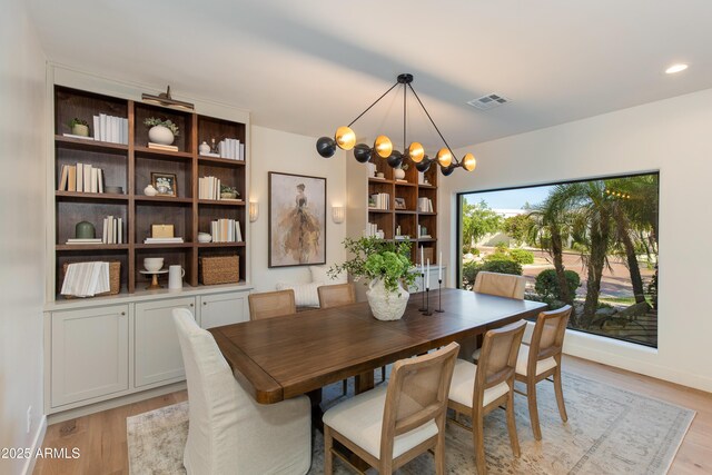 3186 E Stella Ln, Phoenix, AZ 85016 - dining room featuring a chandelier, light wood-style floors, and baseboards