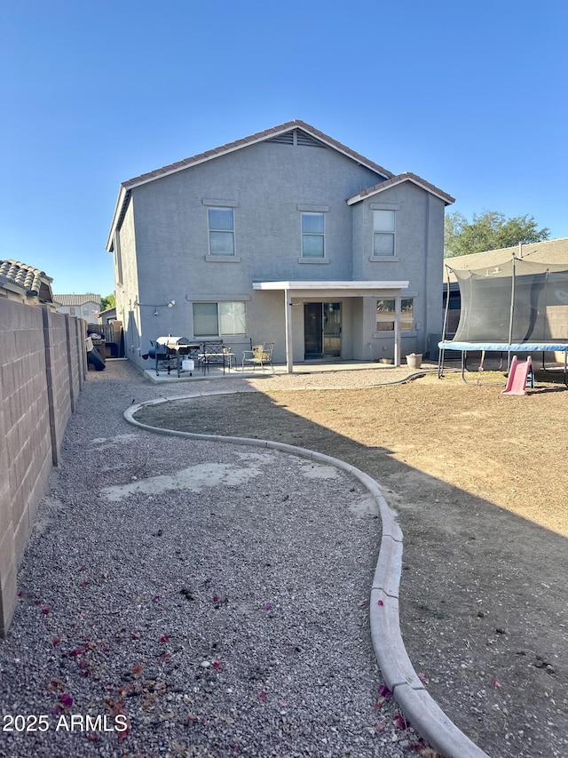 491 E Jeanne Ln, San Tan Valley, AZ 85140 - rear view of property with a trampoline, a fenced backyard, a patio, and stucco siding