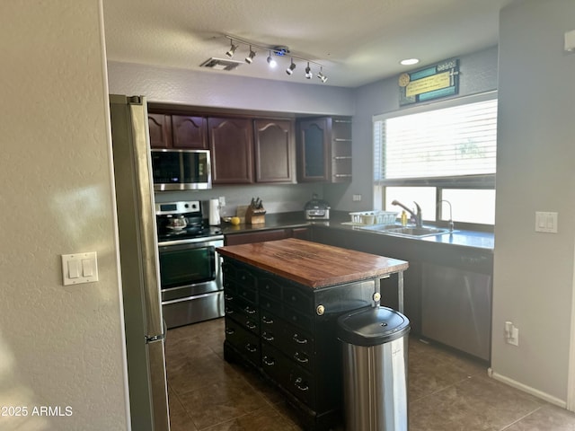 491 E Jeanne Ln, San Tan Valley, AZ 85140 - kitchen with stainless steel appliances, a sink, wood counters, a textured wall, and dark tile patterned floors