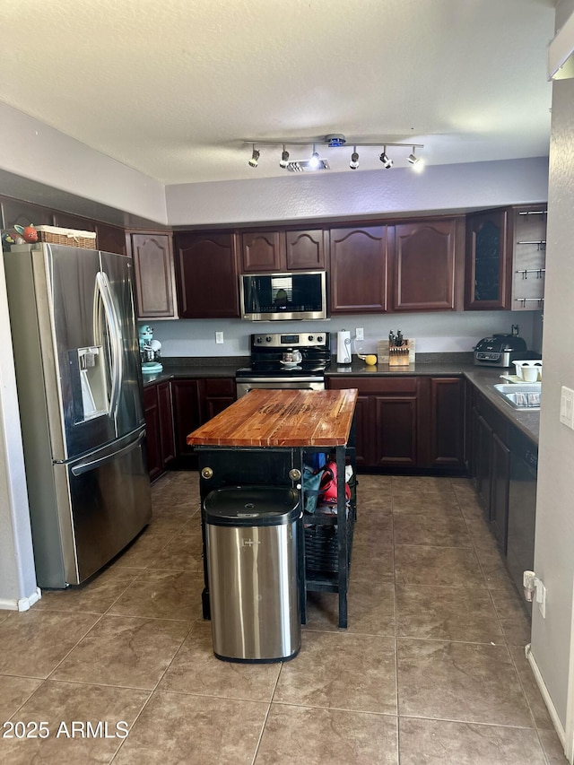 491 E Jeanne Ln, San Tan Valley, AZ 85140 - kitchen featuring stainless steel appliances, butcher block countertops, light tile patterned floors, and dark brown cabinetry