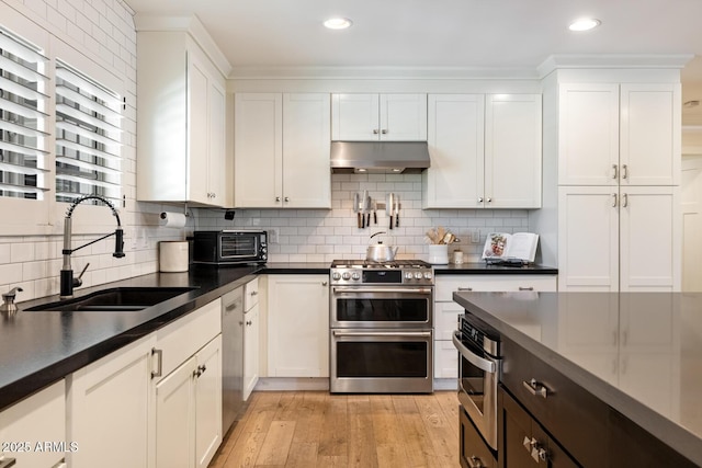 3308 N 51st St, Phoenix, AZ 85018 - kitchen with under cabinet range hood, a sink, appliances with stainless steel finishes, dark countertops, and recessed lighting