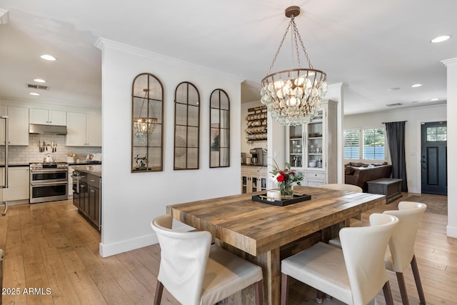3308 N 51st St, Phoenix, AZ 85018 - dining space with a chandelier, baseboards, light wood-type flooring, recessed lighting, and crown molding