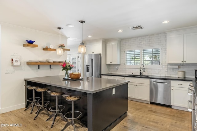 3308 N 51st St, Phoenix, AZ 85018 - kitchen with stainless steel appliances, a sink, tasteful backsplash, white cabinetry, and a breakfast bar area