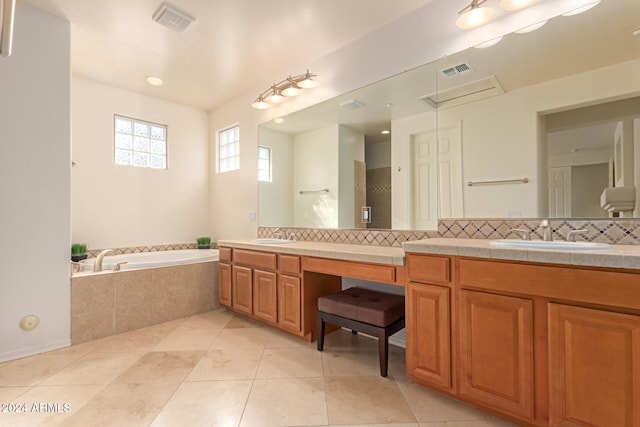 bathroom featuring tiled bath, decorative backsplash, tile patterned flooring, and vanity