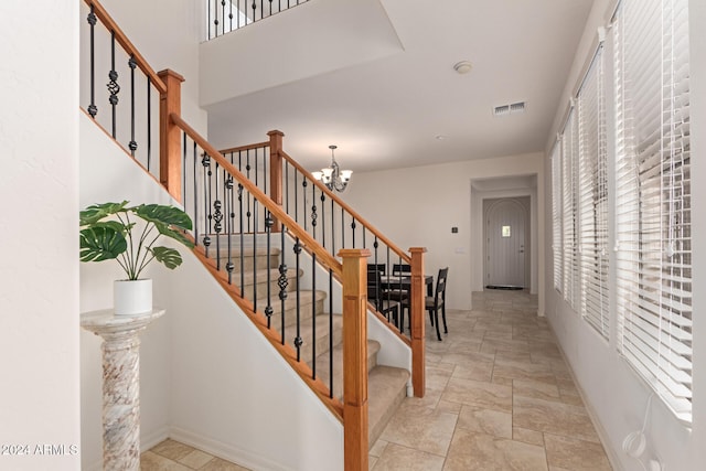 stairway with a chandelier