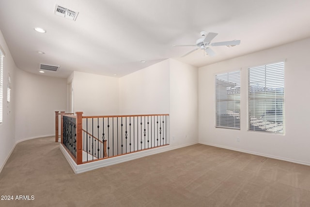 carpeted spare room with ceiling fan