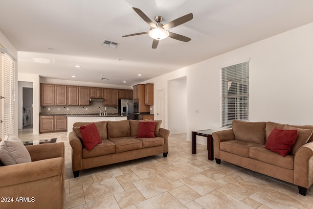 living room with washer / clothes dryer and ceiling fan