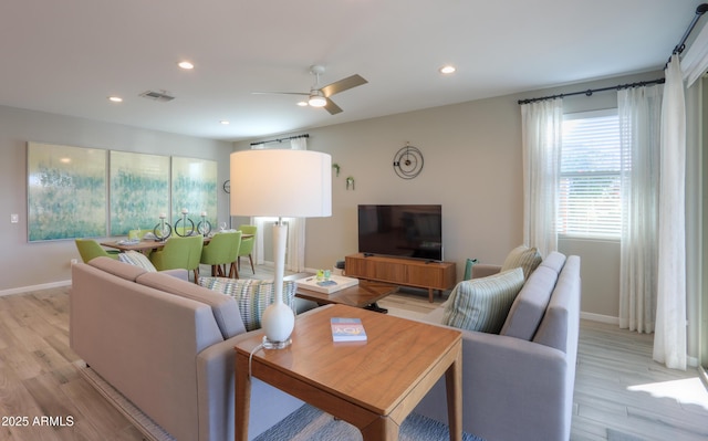 living room featuring ceiling fan and light wood-type flooring