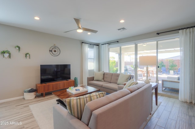 living room featuring ceiling fan and light hardwood / wood-style floors