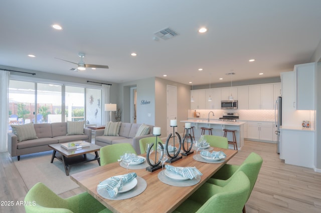 dining room with ceiling fan and light hardwood / wood-style floors