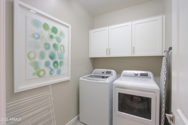 clothes washing area featuring cabinets and washer and dryer