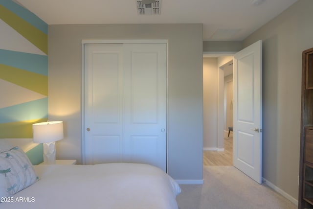 bedroom featuring light colored carpet and a closet